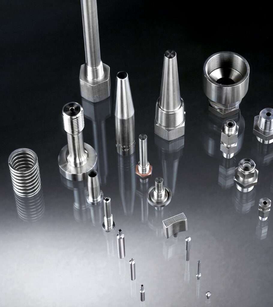 Metallische Präzisionsdrehteile und Gewindefittings auf dunkler Oberfläche