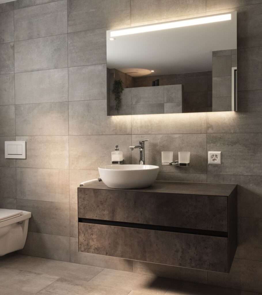 Modernes Badezimmer mit Waschtisch, Aufsatzwaschbecken und beleuchtetem Spiegel