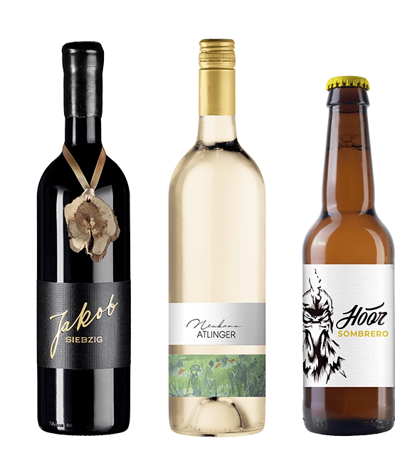Drei Flaschen Wein und Bier nebeneinander.