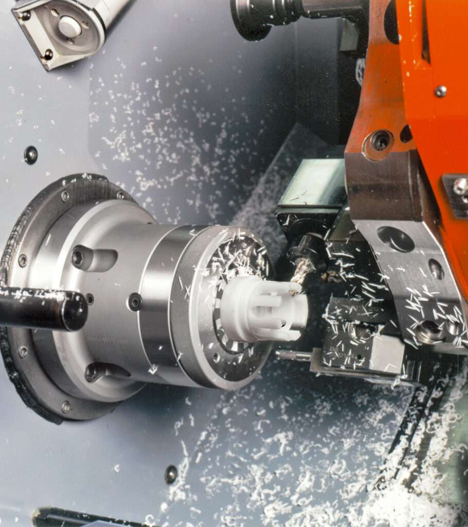 CNC-Drehmaschine beim Fräsen eines Werkstücks, mit Metallspänen im Arbeitsraum
