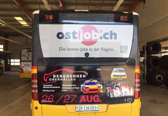 Werbebeschriftung auf der Rückseite eines Busses für ostjob.ch und das Bergrennen Oberhallau 26./27. Aug