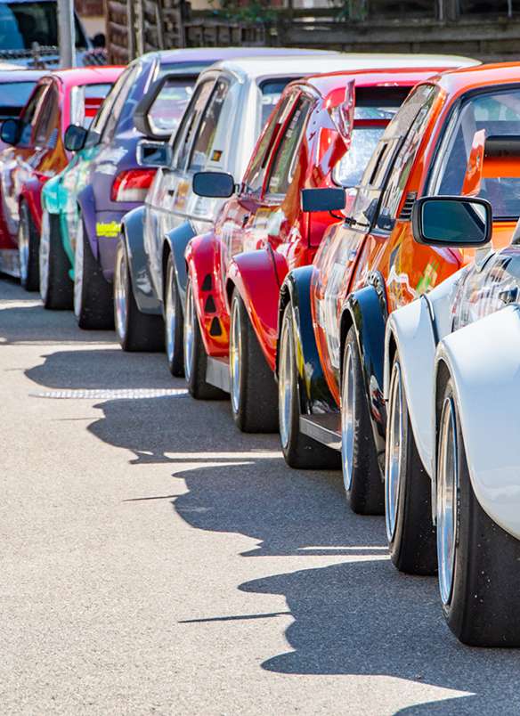 Reihe bunter Sportwagen, die am Straßenrand geparkt sind