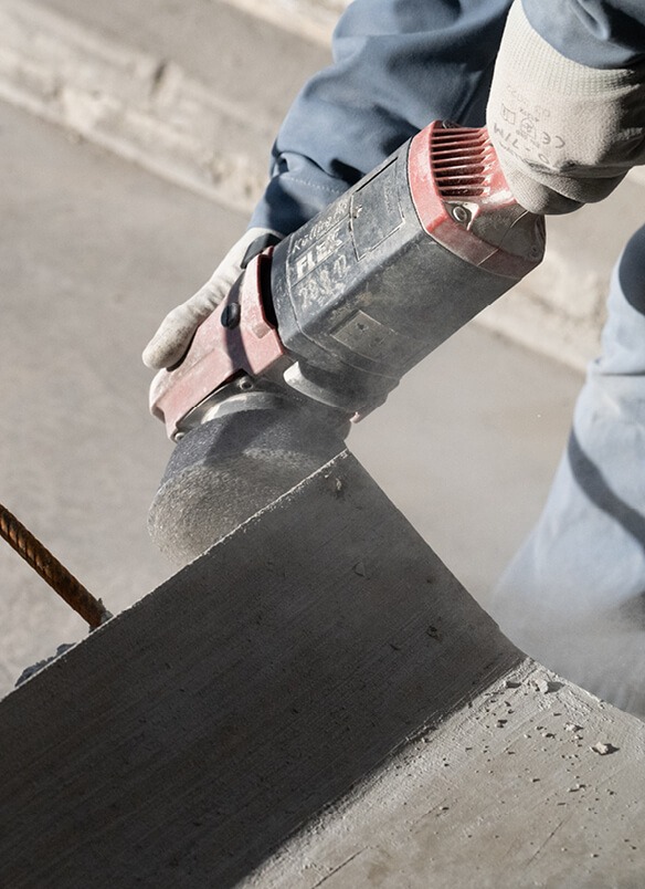 Ein Arbeiter schneidet mit einer Trennsäge Beton